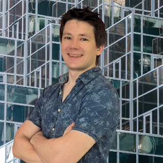 David Robert standing in front of a glass building.